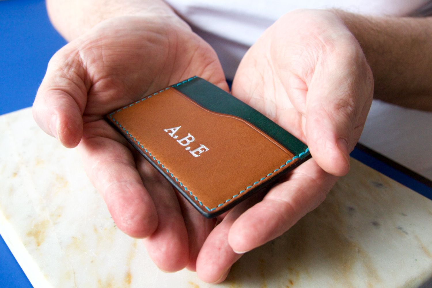 leather craftsman holds card holder