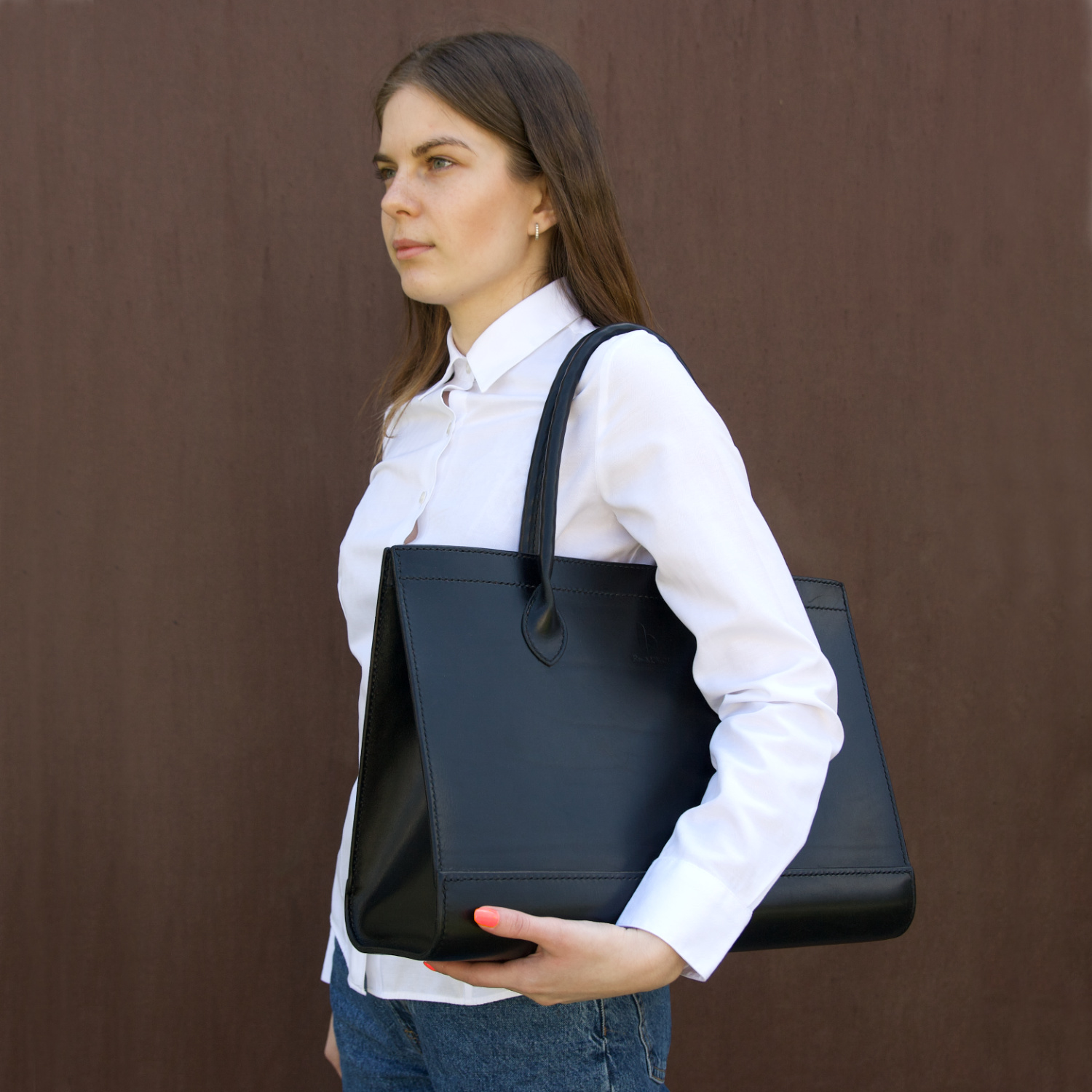 model holding leather tote bag with round handles