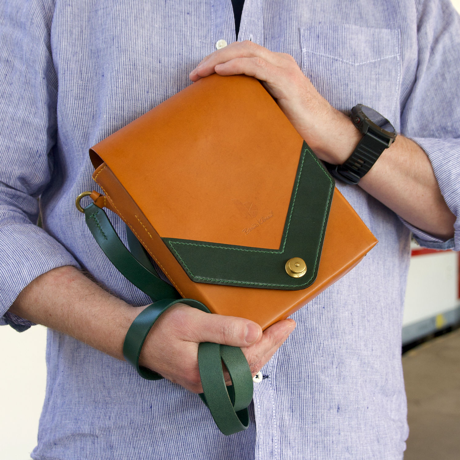 leather messenger bag held in hands